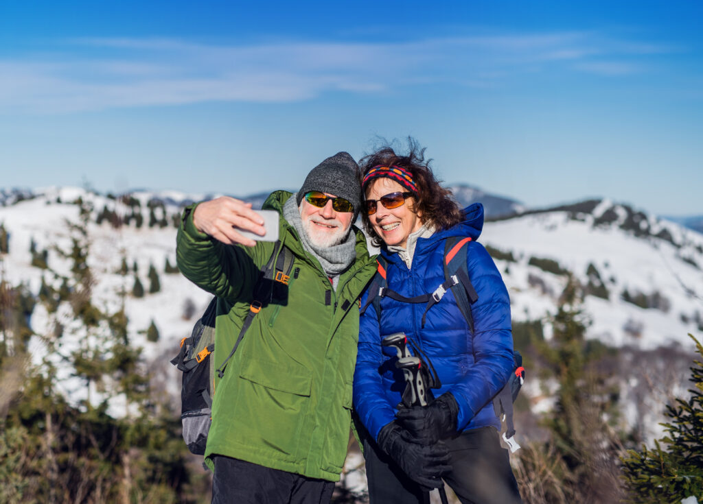 A couple taking a selfie on a snowy mountain.