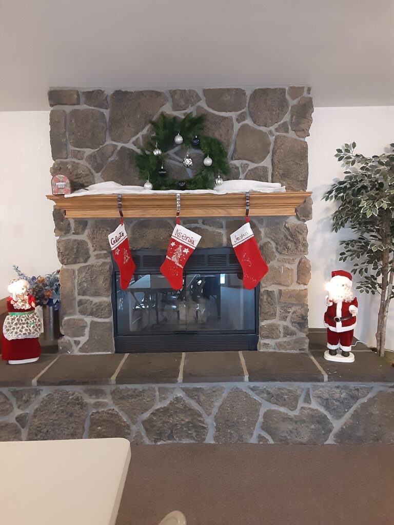 A fireplace with santa claus stockings on it.