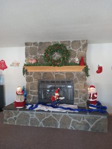 A festive fireplace adorned with decorations and a wreath, spreading happy holiday vibes.
