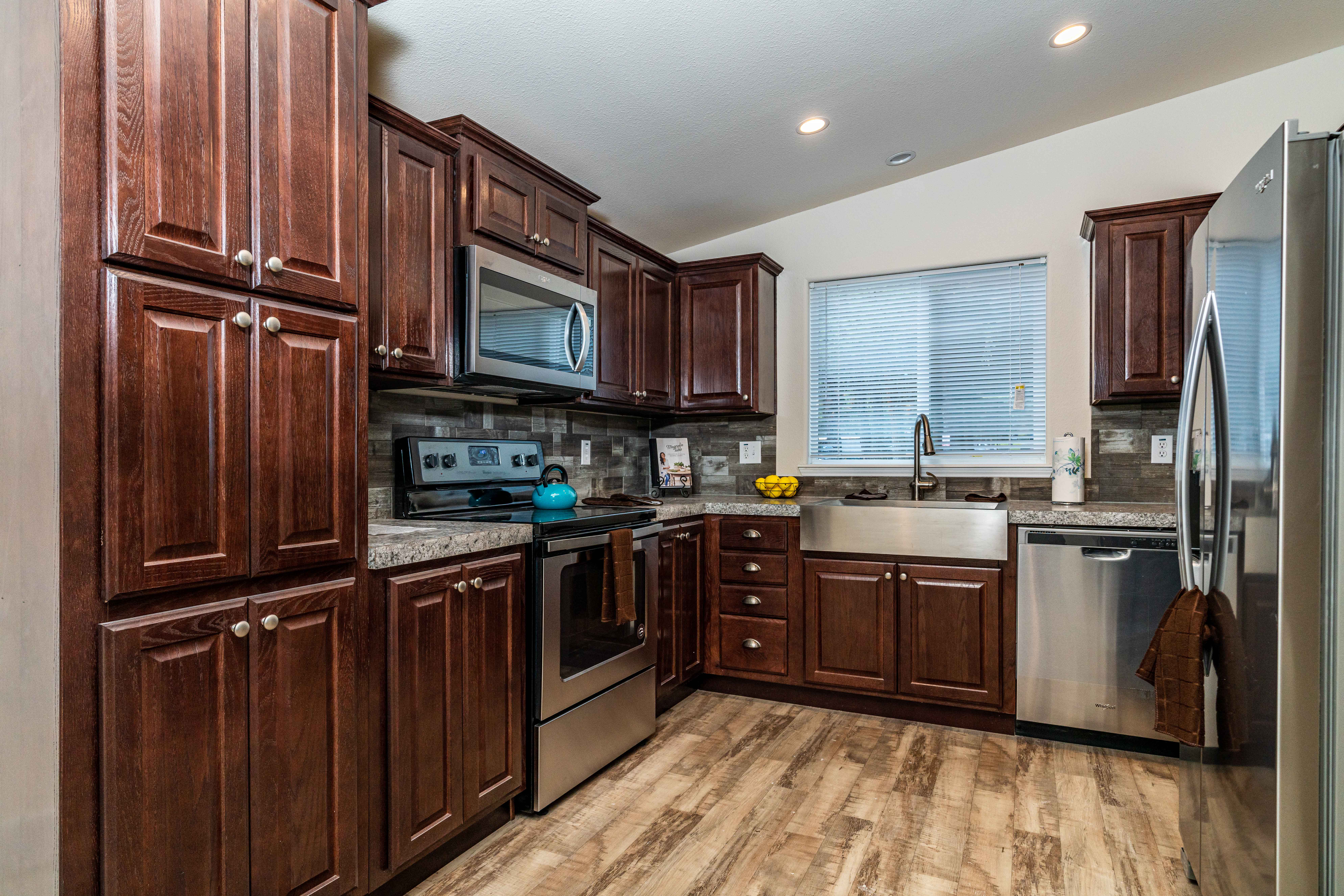 A kitchen with dark wood cabinets and granite counter tops.