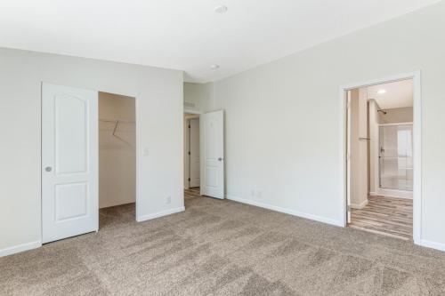 An empty room with a closet and a door.