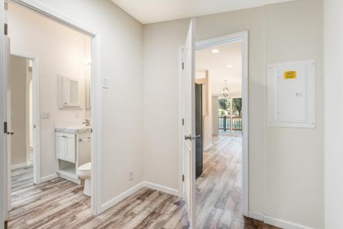 A hallway with white walls and wood floors.