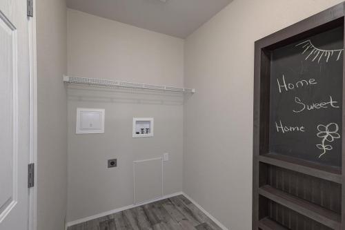 A hallway with a chalkboard and a closet.