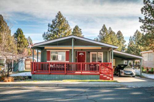 A mobile home with a red front porch.
