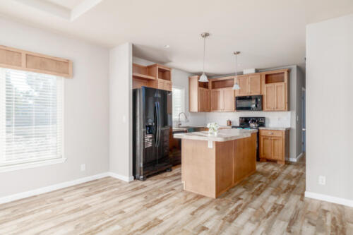 A kitchen with wood floors and wood cabinets.