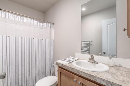 A bathroom with a shower curtain and sink.